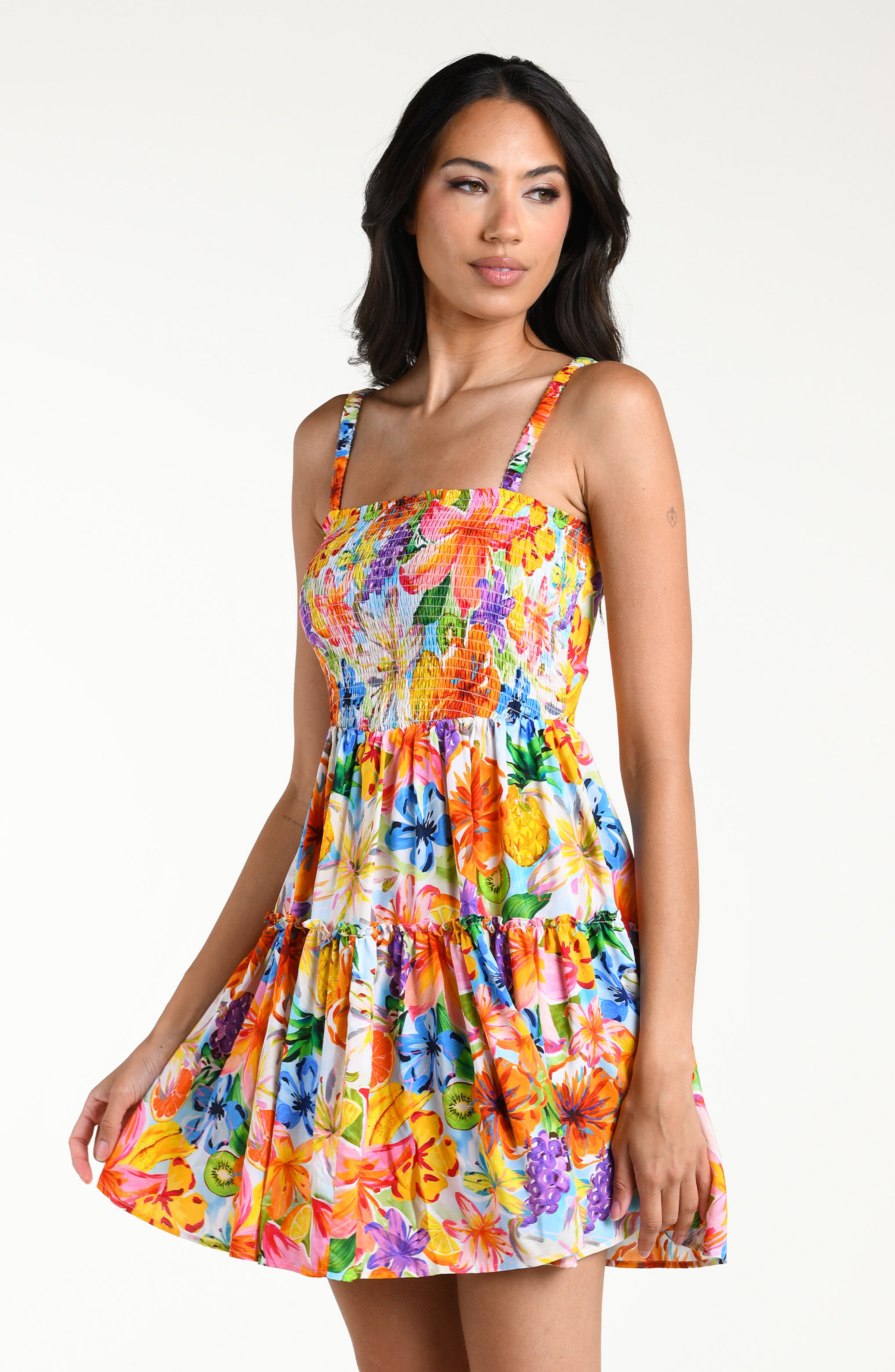 Woman wearing a colorful floral mini dress cover up against a white background