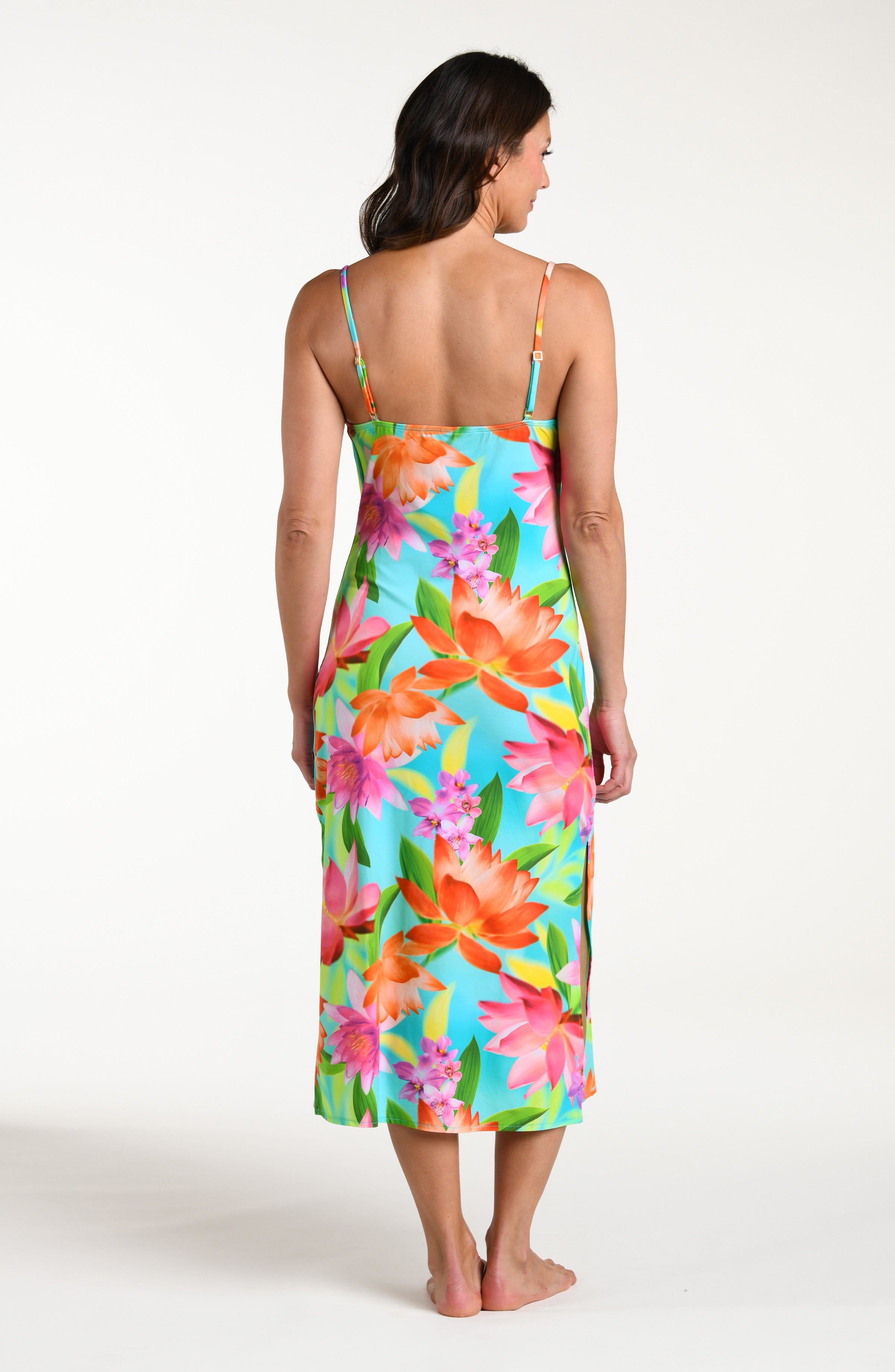 Woman wearing a bright floral midi dress cover up against a white background.