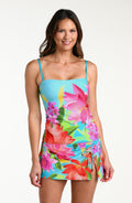 Woman wearing a bright floral tankini top and matching swim skirt against a white background
