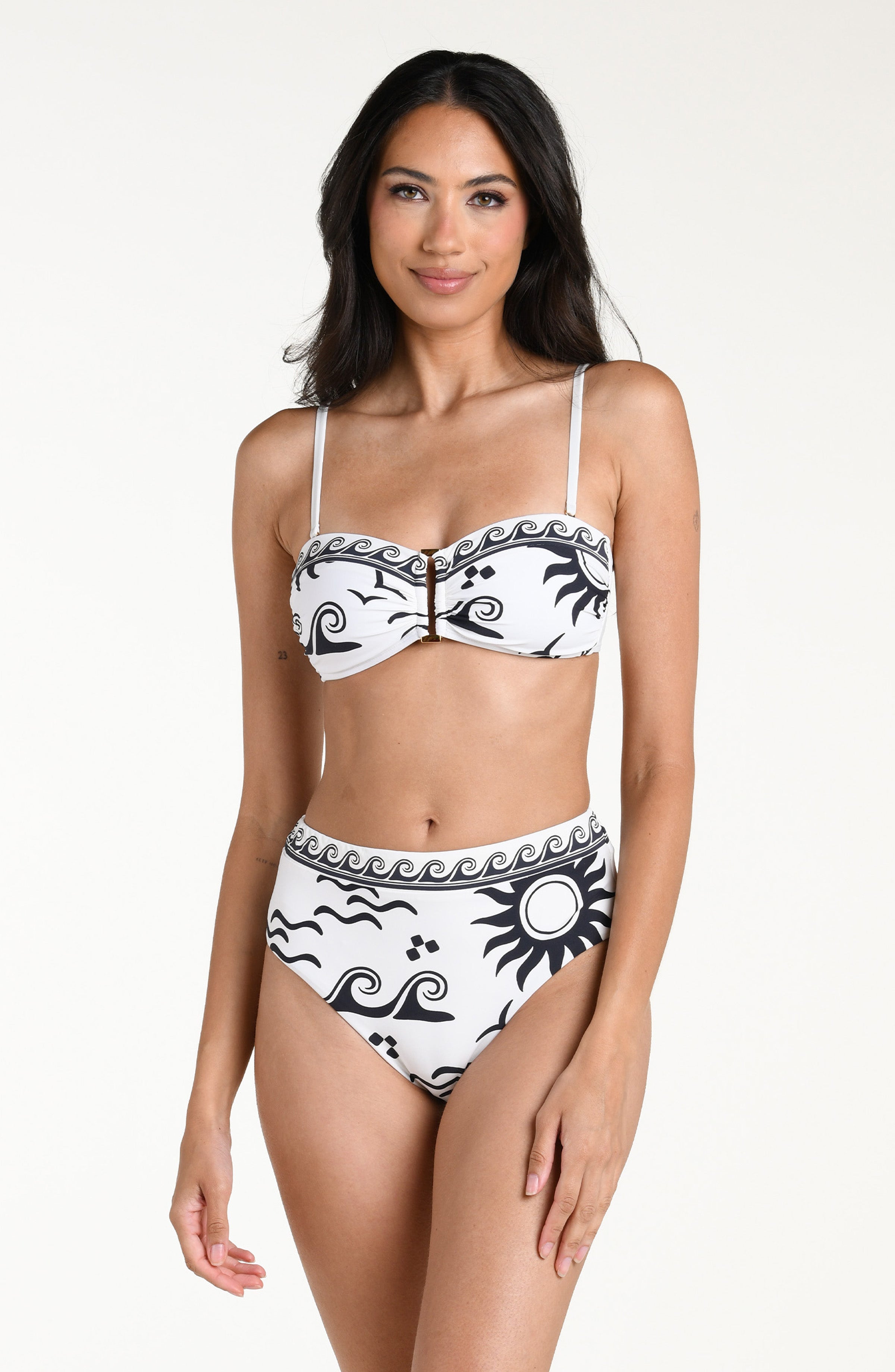 Woman wearing a white bikini with black patterns and a matching bikini bottom against a white background