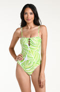 Woman wearing a green and white patterned one piece swimsuit against a white background