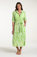 Woman is wearing a green and white leaf-patterned midi dress against a white background