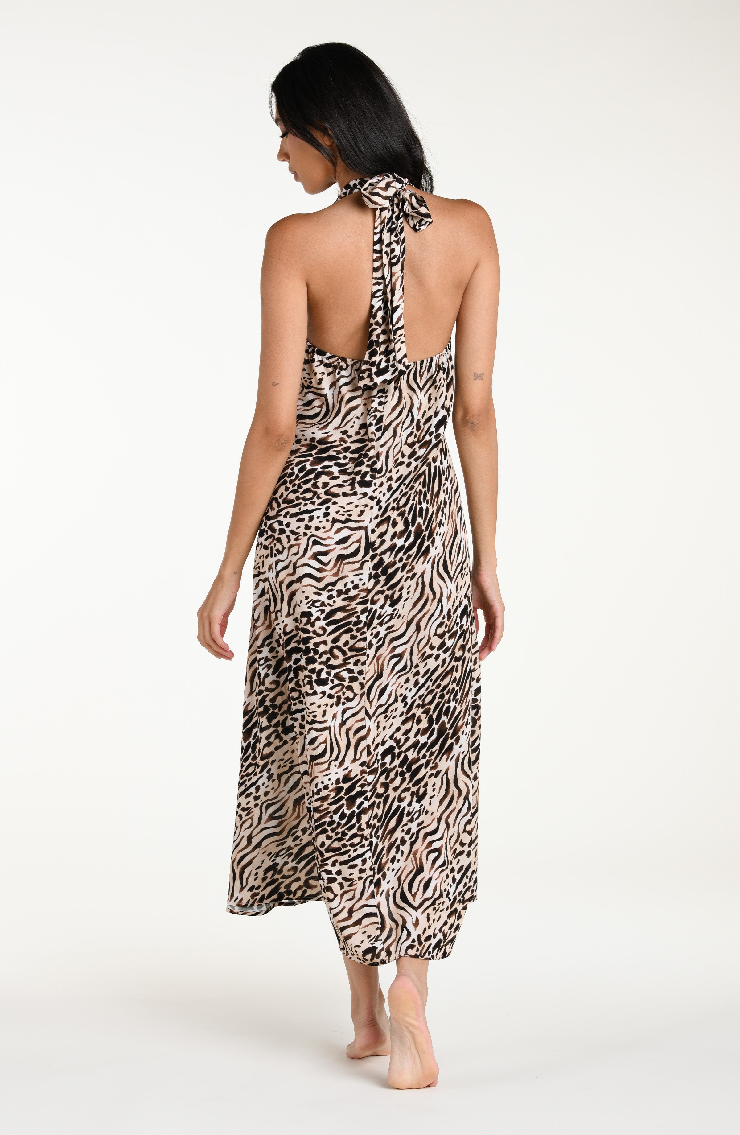 Woman wearing a zebra printed maxi dress cover up against a white background
