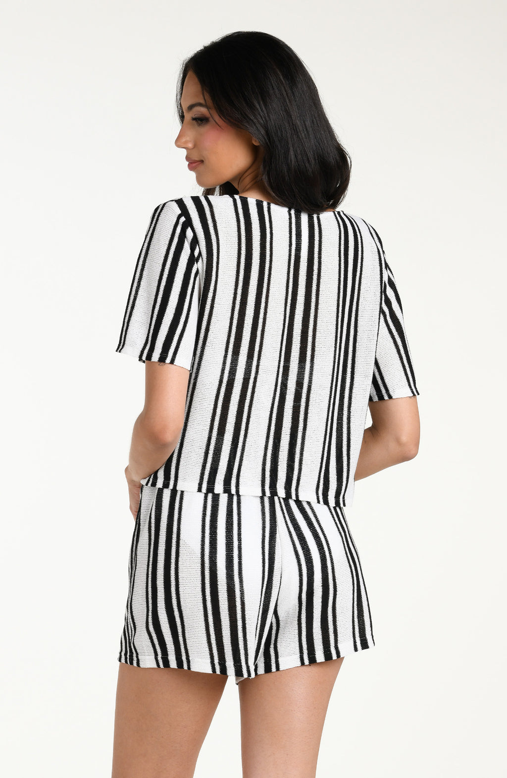 Woman wearing a black and white striped short sleeve top and matching shorts against a white background