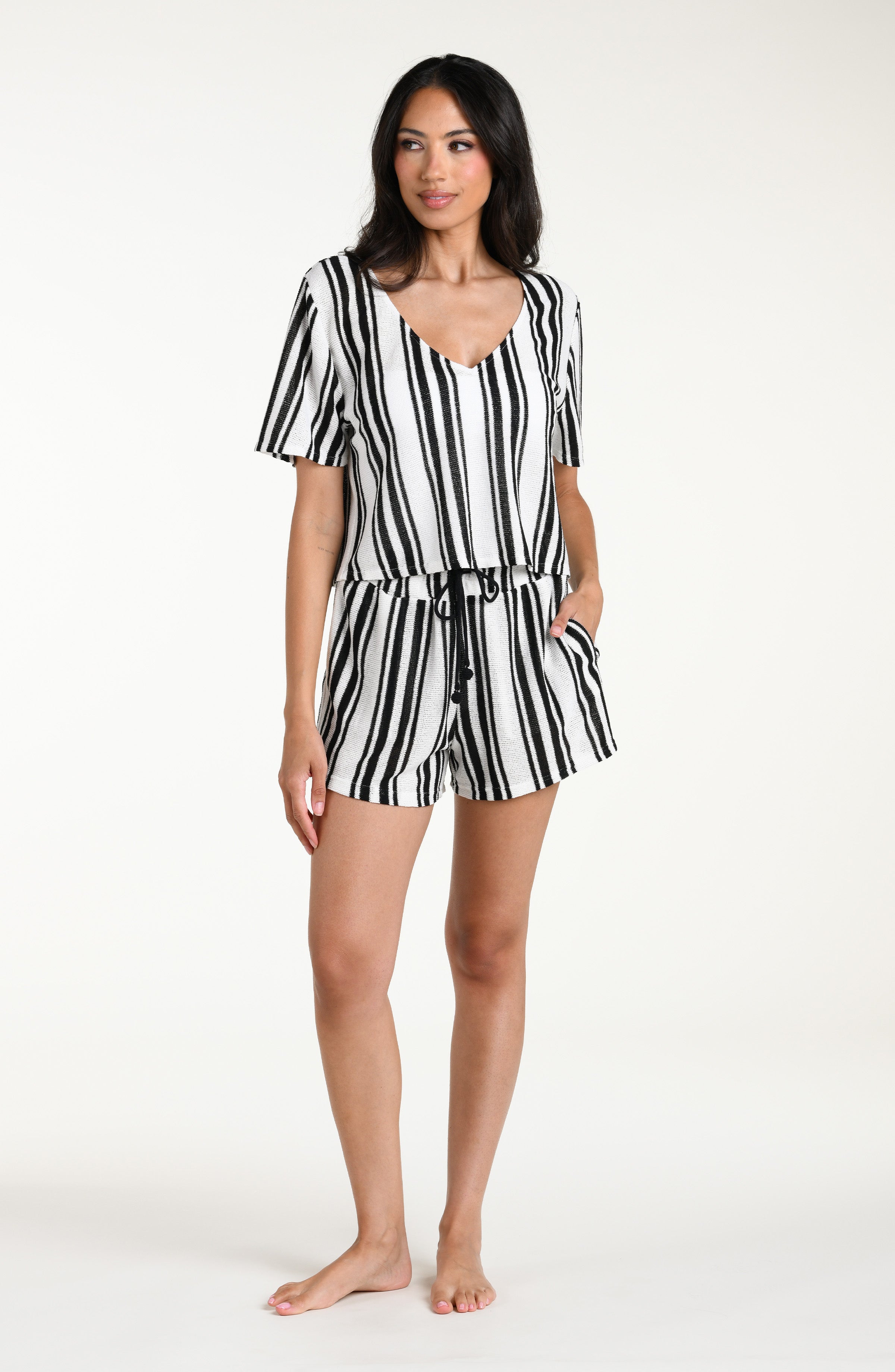 Woman wearing a black and white striped short sleeve top and matching shorts against a white background