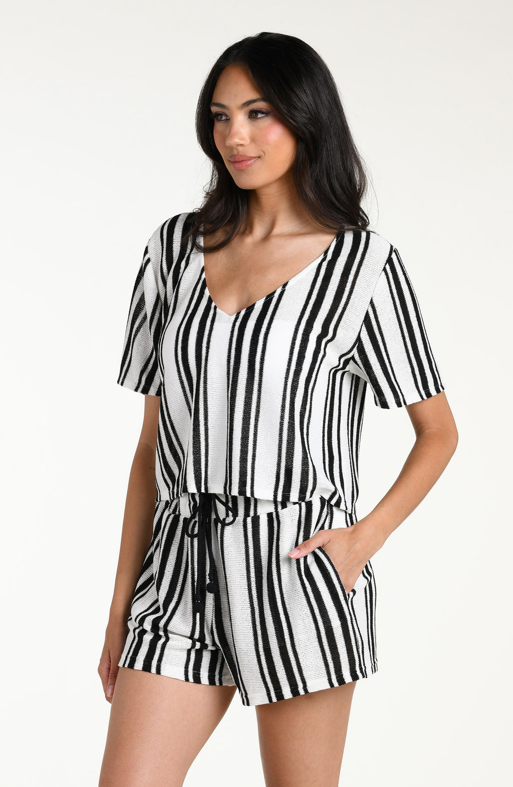 Woman wearing a black and white striped short sleeve top and matching shorts against a white background