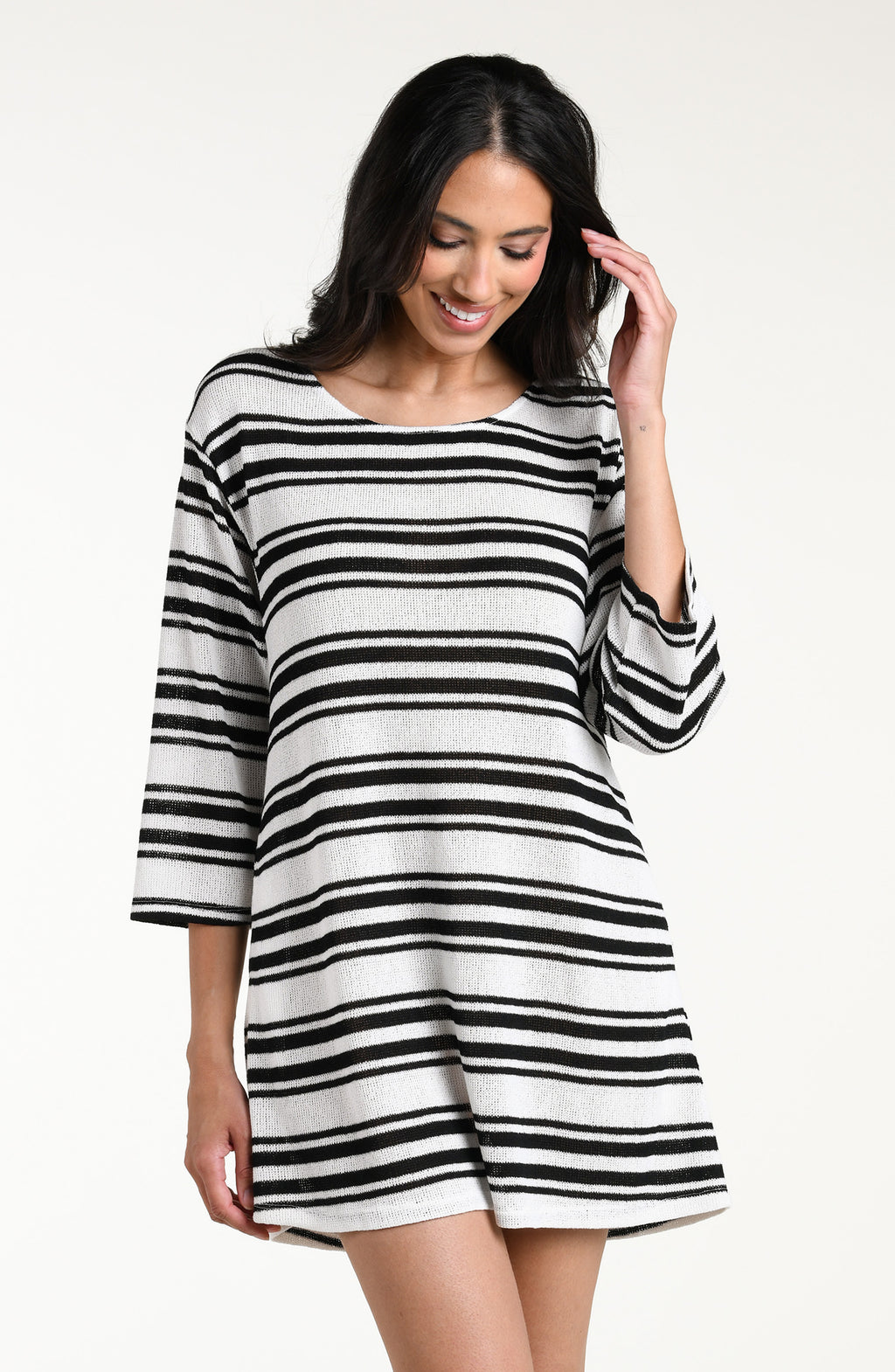 Woman wearing a black and white striped tunic cover up against a white background