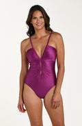 Front image of model wearing a berry colored one-piece swimsuit with thin straps, a plunging neckline accented by keyhole cutouts, and ruched detailing. 
