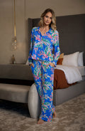 Woman wearing a colorful tropical leaf pattern pajama set