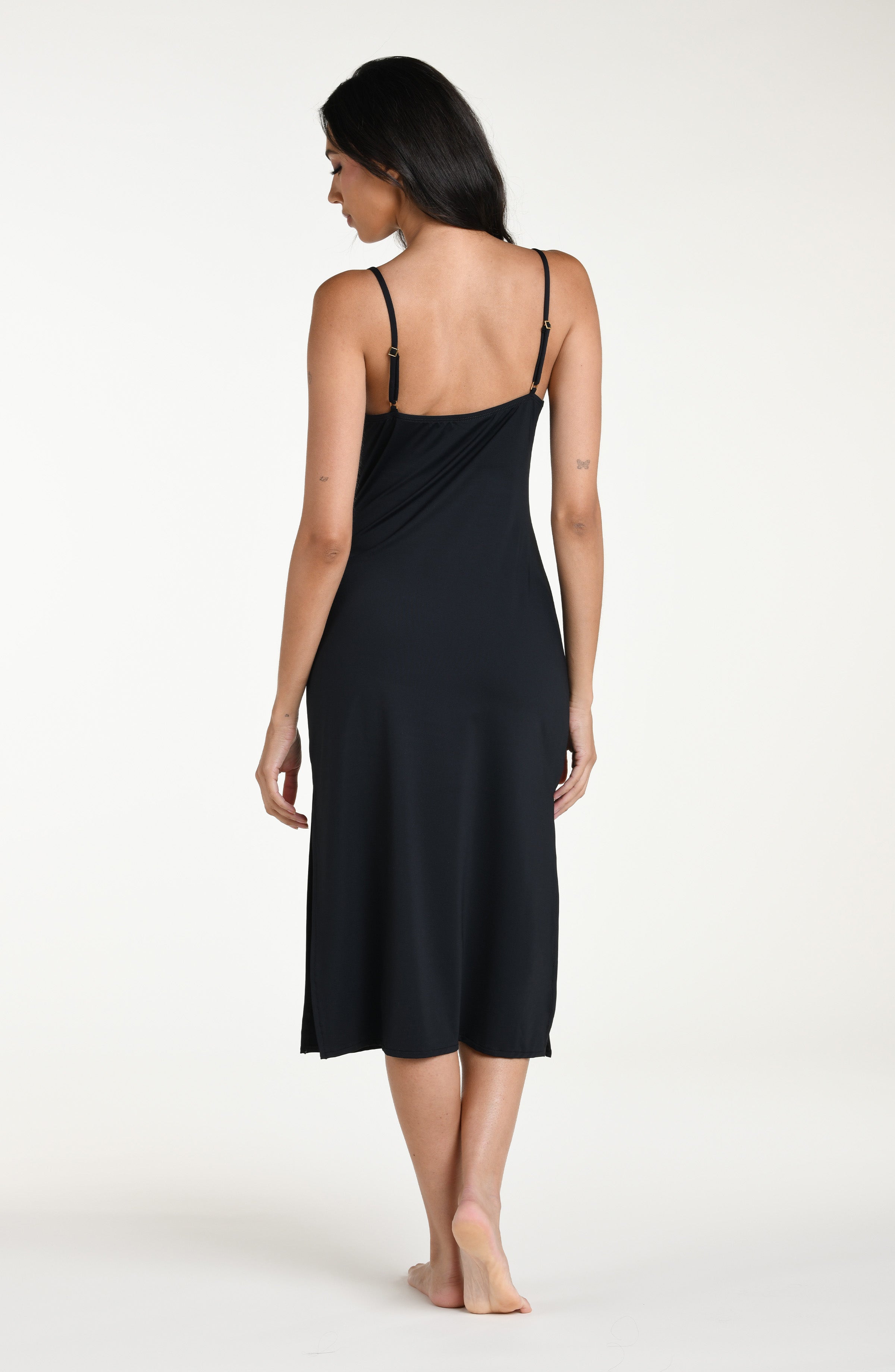 Woman wearing a black midi dress cover up against a white background