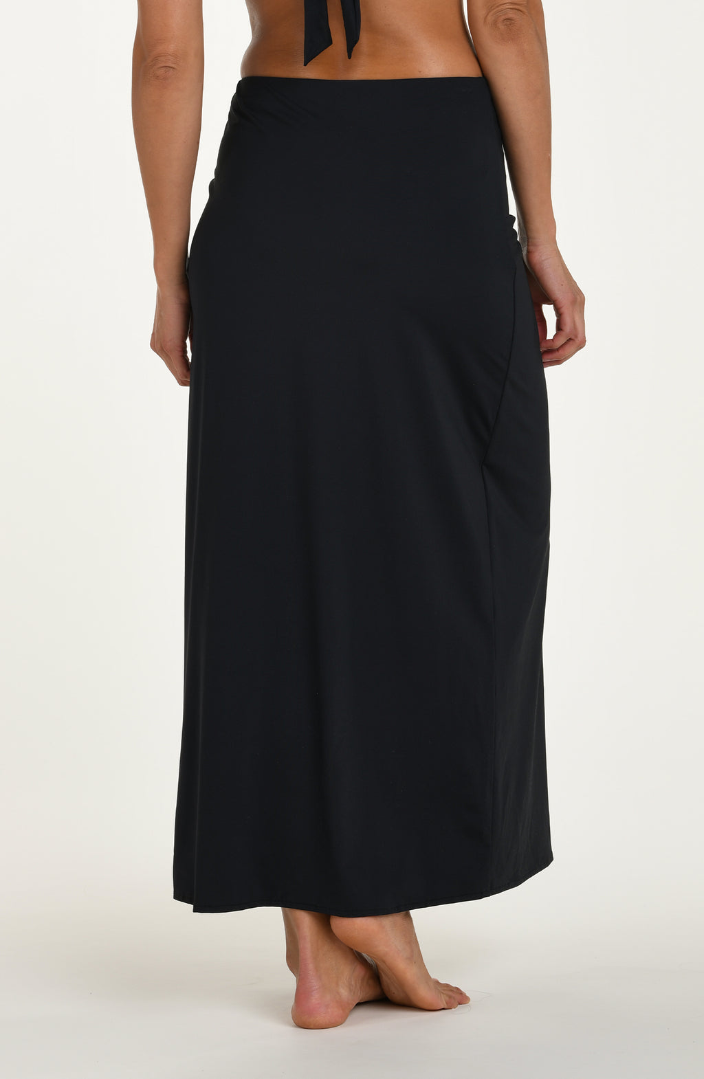 Back image of model wearing a black swim skirt with ruched side detail and a high slit on one leg.