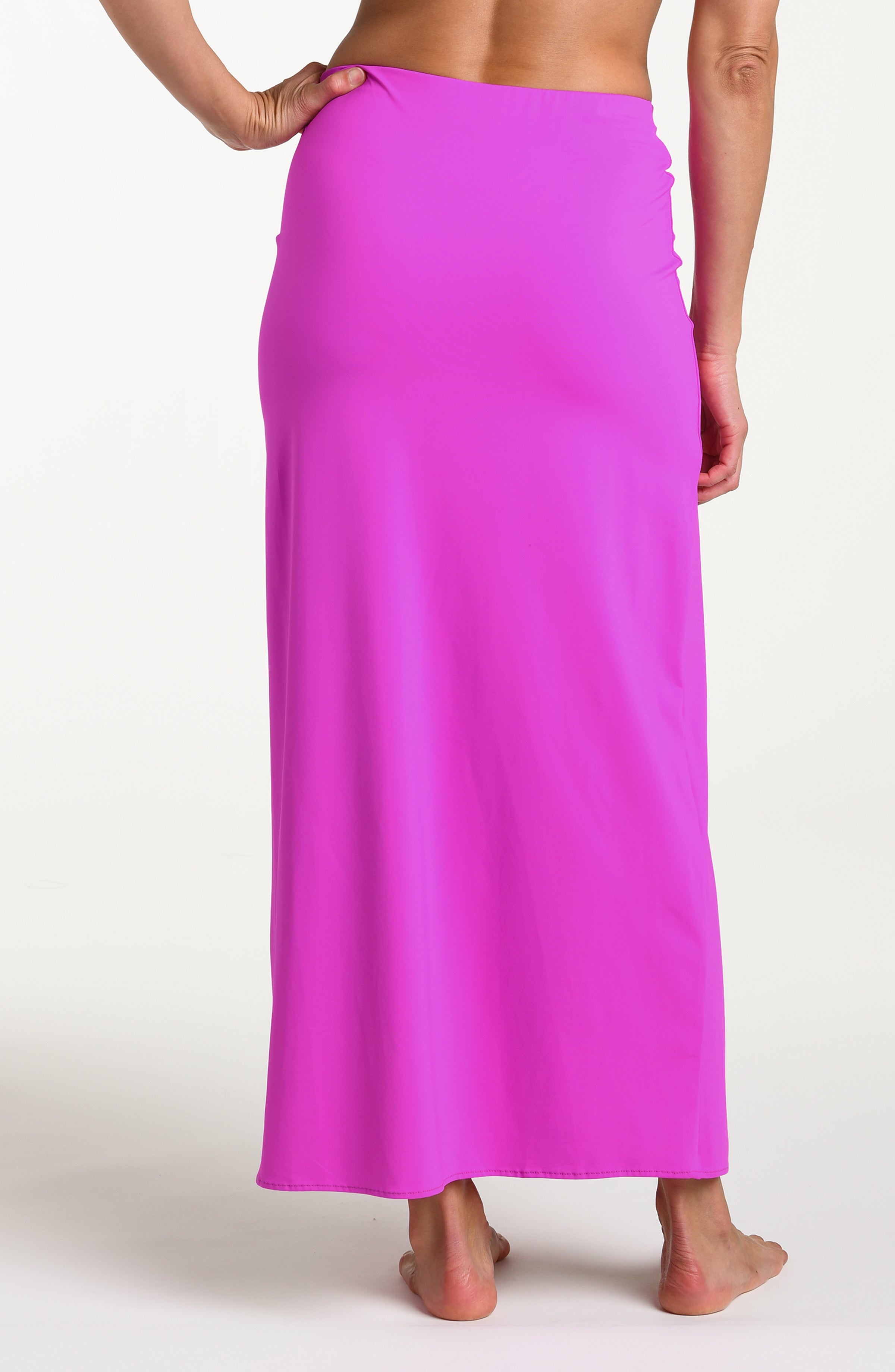 Woman wearing a violet colored maxi skirt against a white background. 