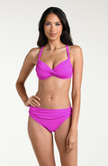 Woman wearing a violet colored bikini top and matching bottom against a white background