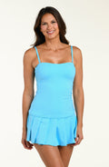 Woman wearing a light blue tankini top and matching swim skirt against a white background