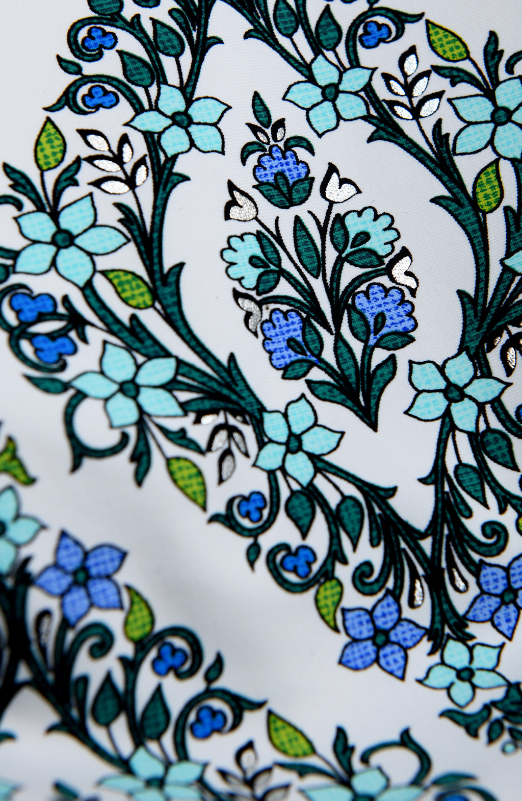 Close-up of a floral pattern with blue and green flowers on a white background