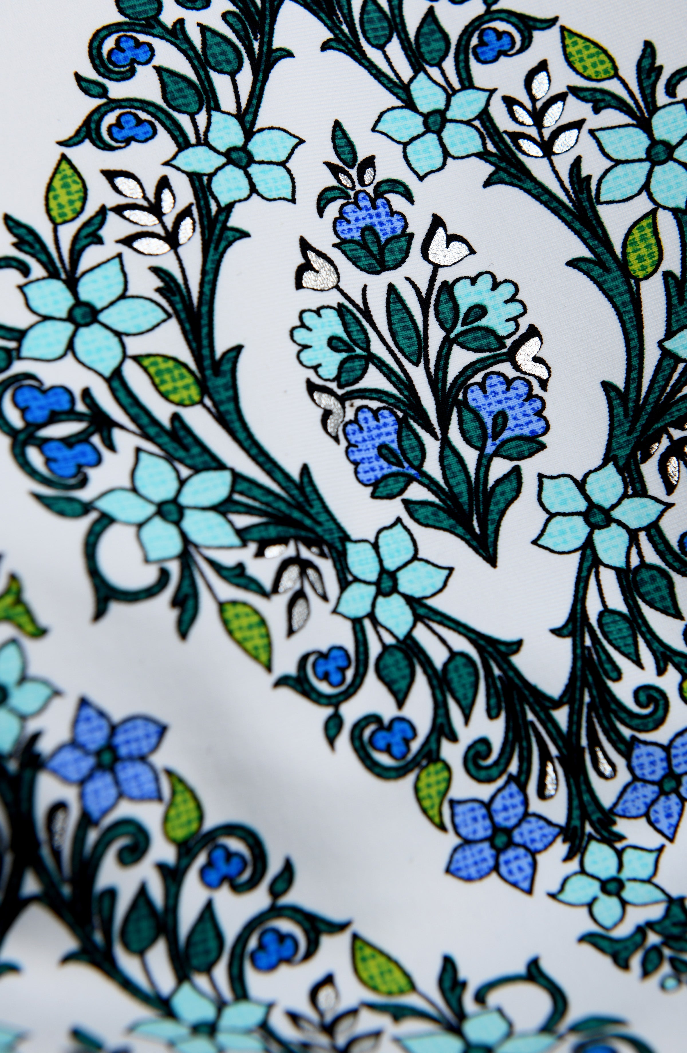 Close-up of a floral pattern with blue and green flowers on a white background