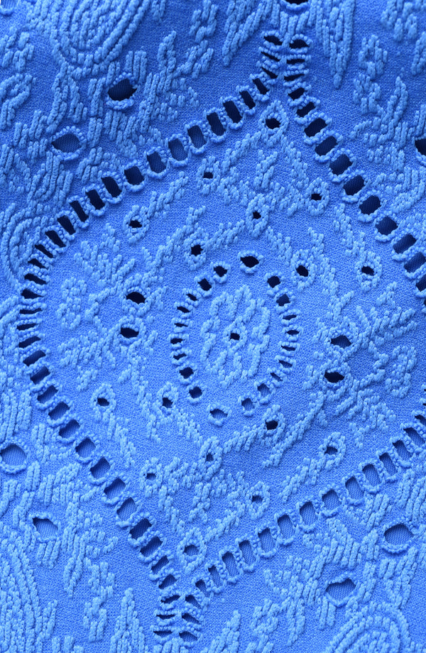 Close-up of blue lace fabric with intricate patterns