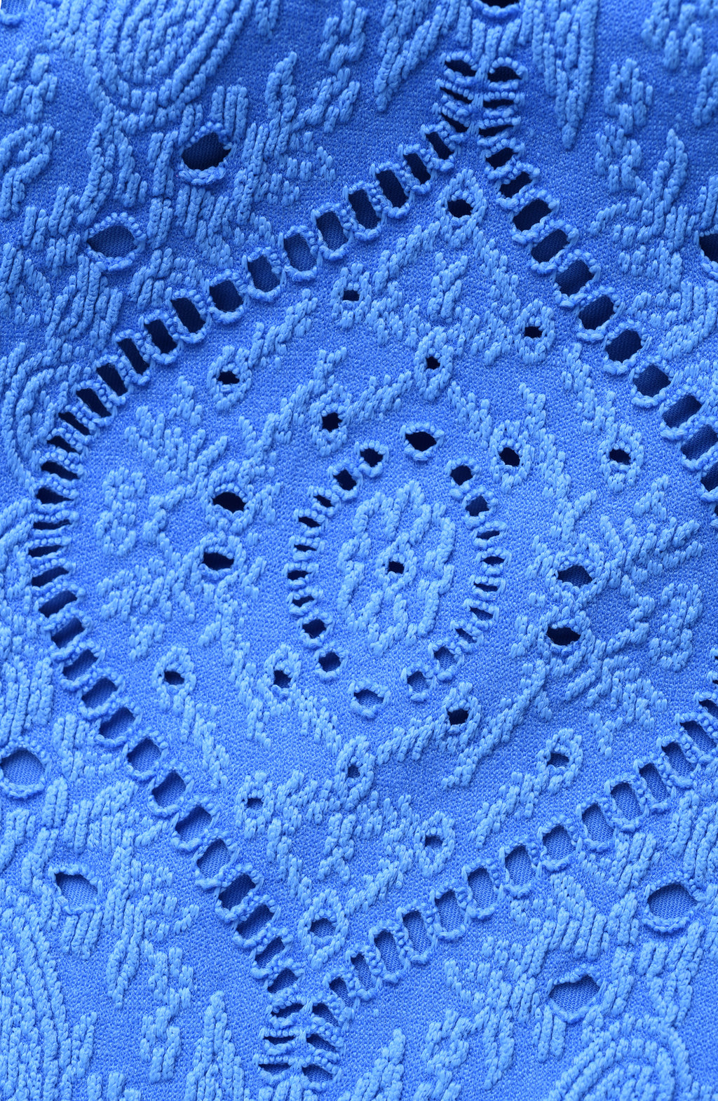 Close-up of blue lace fabric with intricate patterns