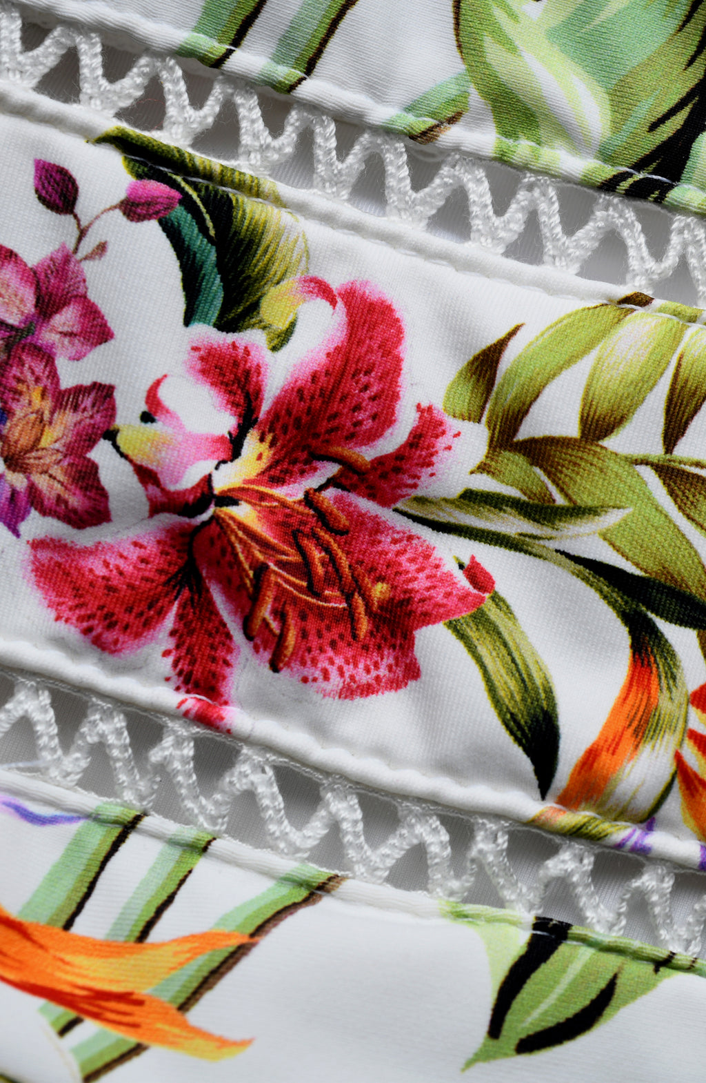 Close-up of a floral fabric with pink flowers and green leaves on a white background.