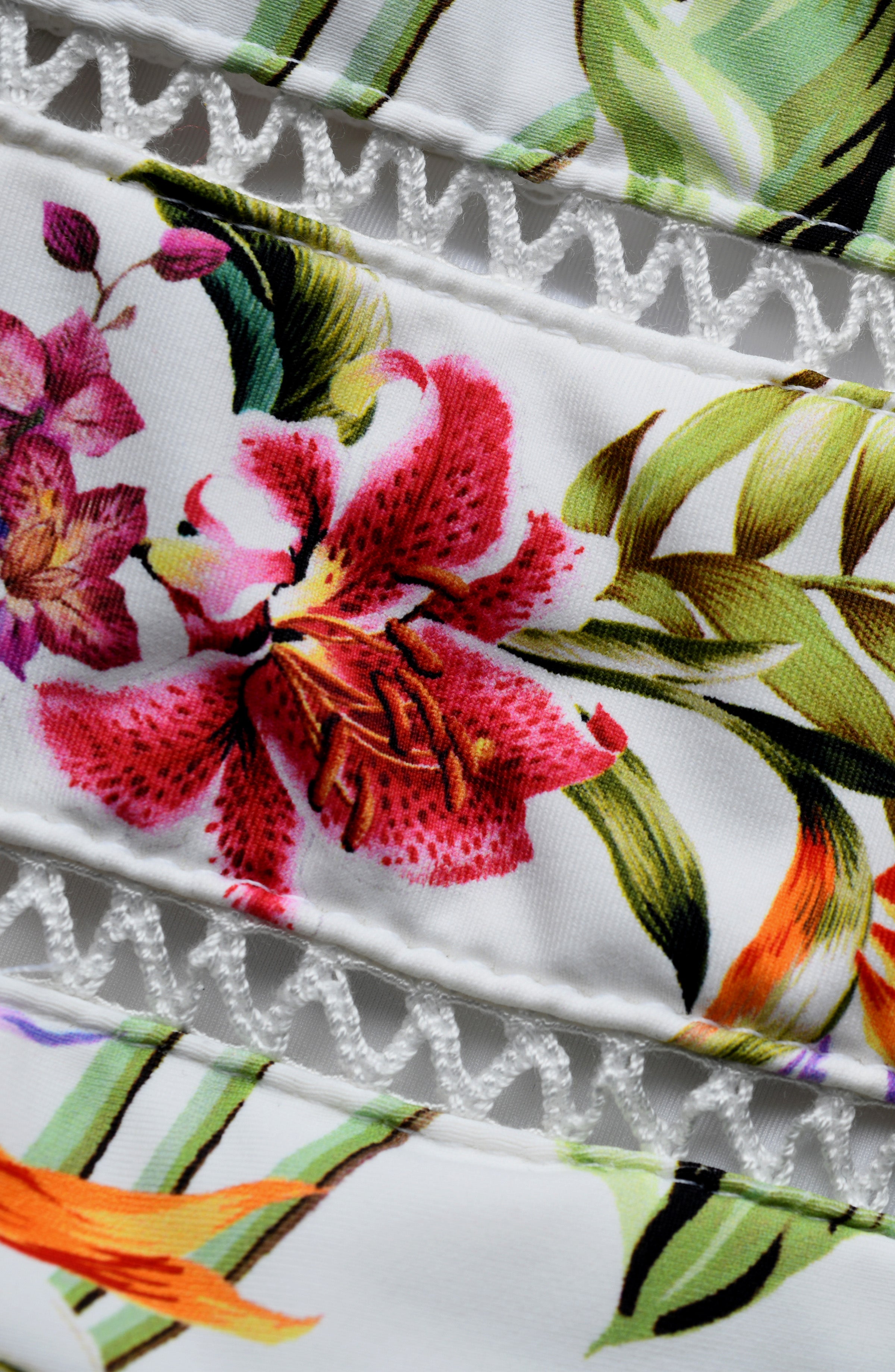 Close-up of a floral fabric with pink flowers and green leaves on a white background.