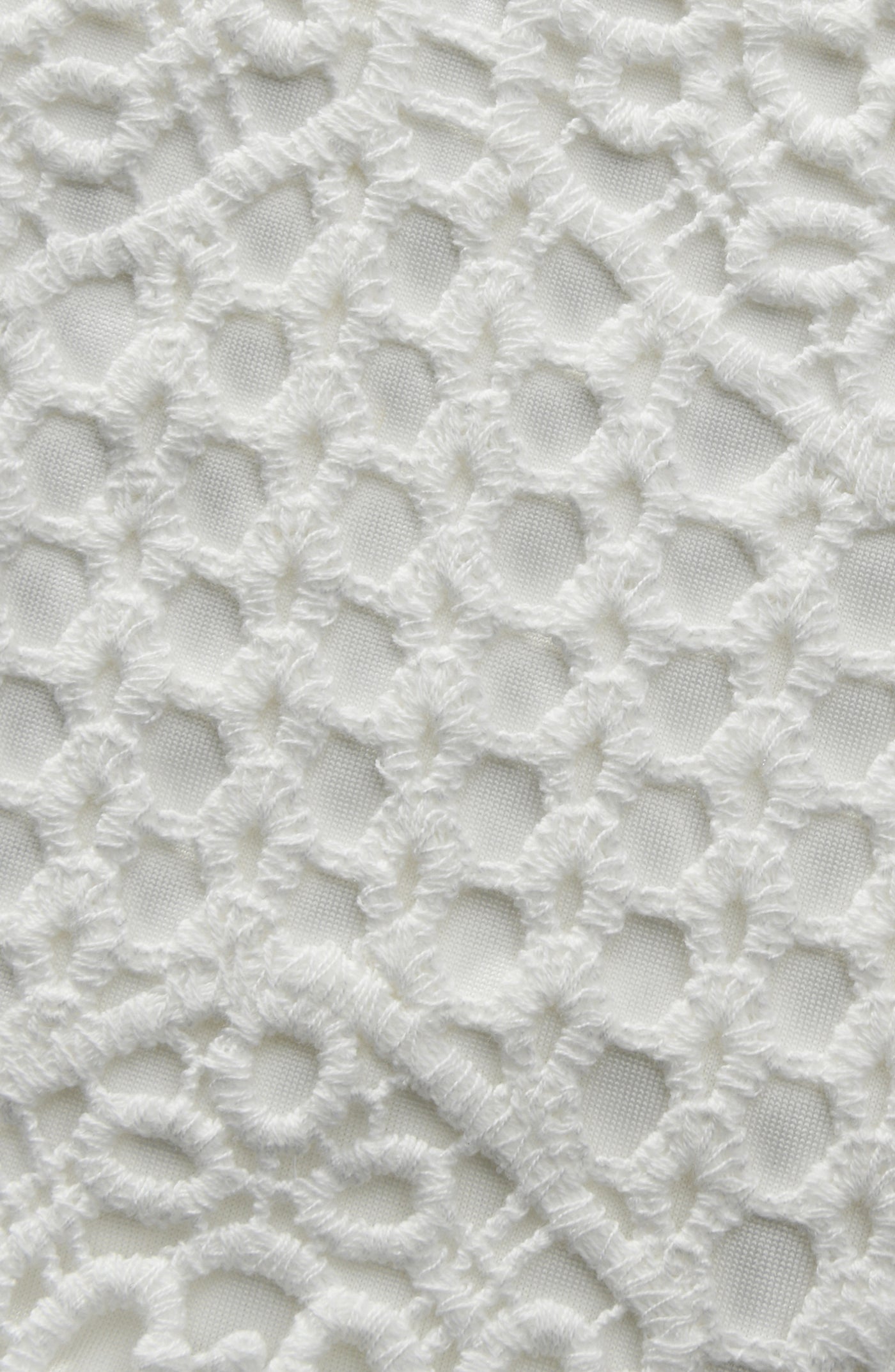 
                  
                    Close-up of a textured white surface with a lattice pattern
                  
                