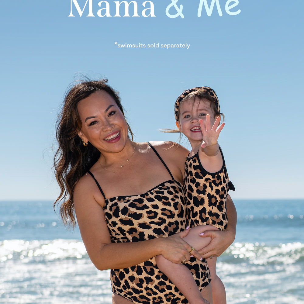 
                  
                    Toddler is wearing a black and tan leopard printed high neck one piece from our Mama and Me Running Wild collection.
                  
                