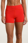 Woman wearing red biker shorts against a white background