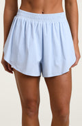 Light blue running shorts worn by a person against a beige background