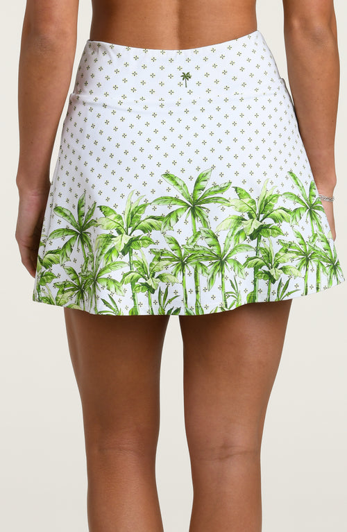 White skort with green palm tree pattern worn by a person on a plain background