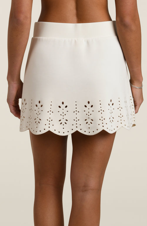 Woman wearing a beige skirt with cut-out details on a beige background