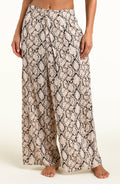Wide-leg pants with a beige, black, and brown snakeskin pattern, shown on a model against a plain white background.