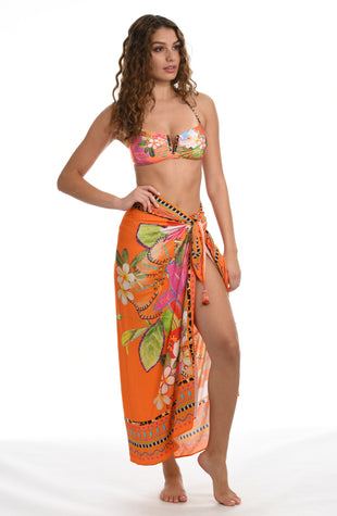 Model is wearing an orange multicolored tropical printed pareo wrap cover up from our In A Trance collection. 