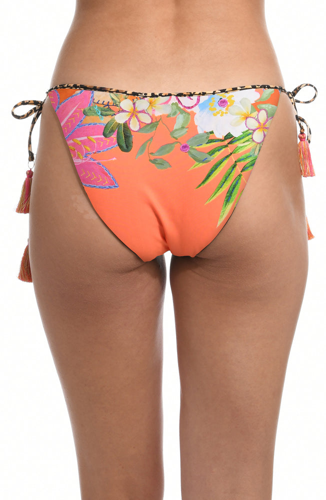 Model is wearing an orange multicolored tropical printed side tie hipster bikini bottom from our In A Trance collection. 