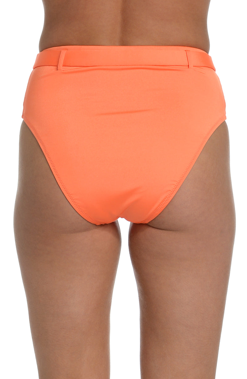 Model is wearing a solid bright coral colored high waist bikini bottom from our Wanderlust Solids collection.