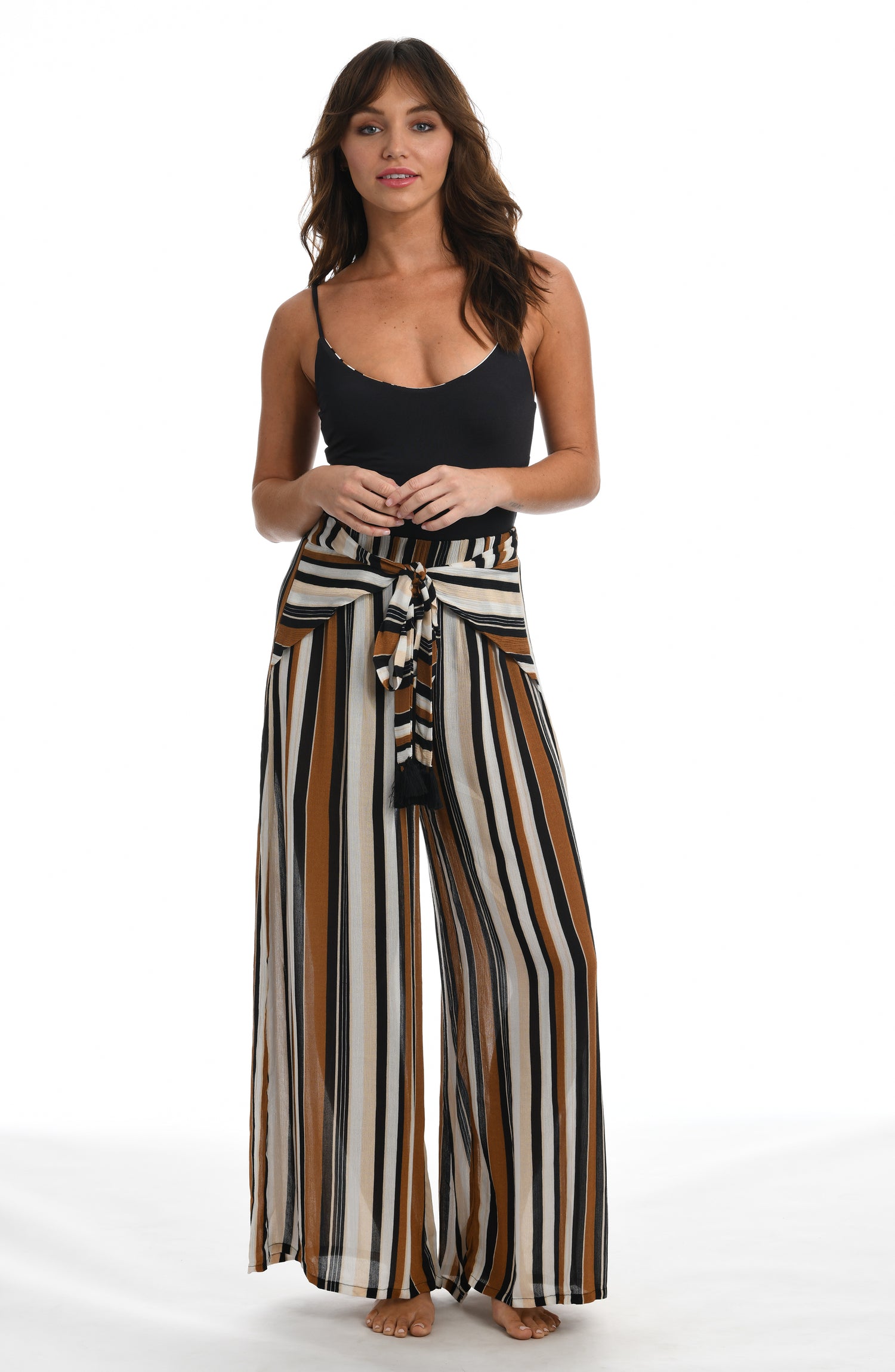 Model is wearing a retro inspired printed beach pant swimsuit cover up with diagonal stripes and floral medallions in brown earthy tones from our 70's Stripe collection.