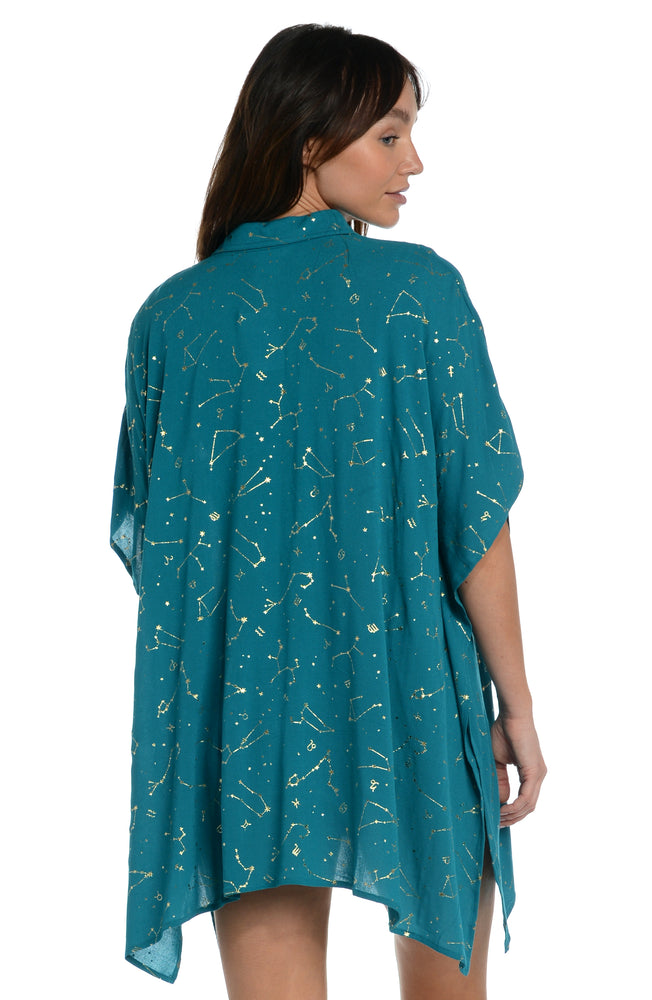 Model is wearing a solid teal colored resort button down cover up shirt from our Zodiac collection.
