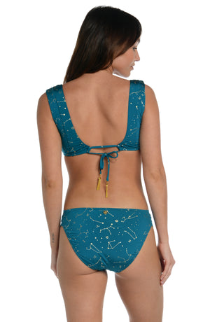 Model is wearing a solid teal colored over the shoulder bralette bikini top from our Zodiac collection.
