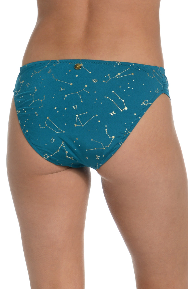 Model is wearing a solid teal colored side shirred hipster bikini bottom from our Zodiac collection.