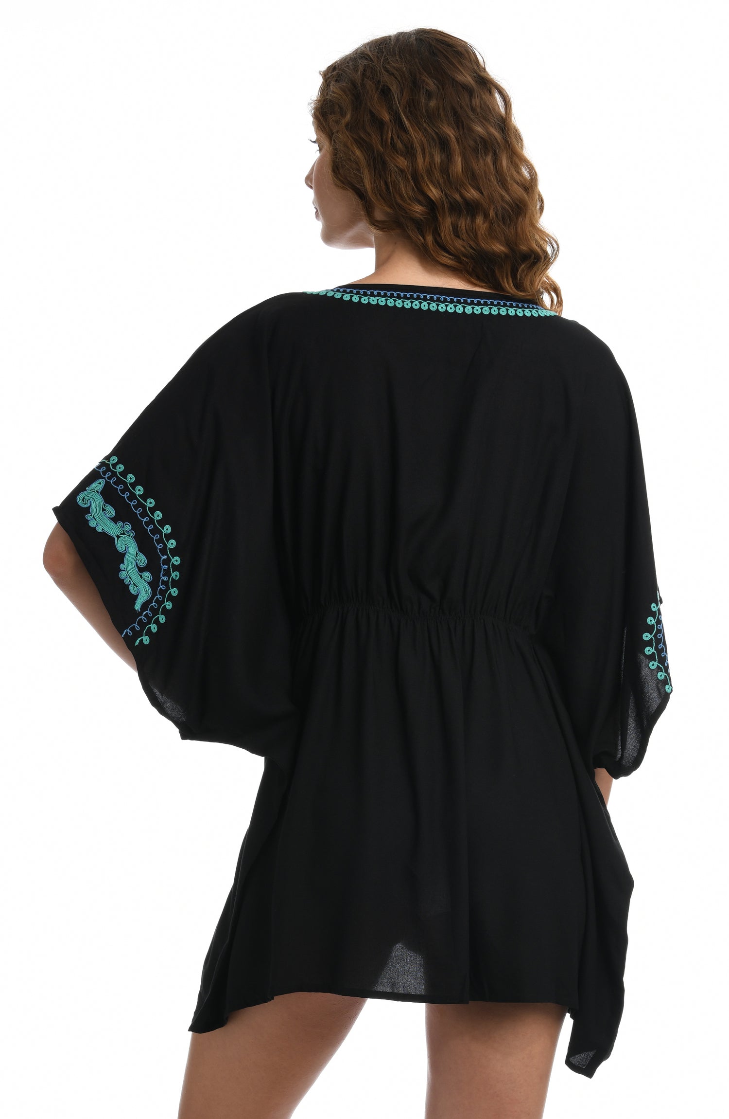 Model is wearing a black V-Neck tunic swimsuit cover up detailed with turquoise embroidered accents from our Hippie Trail collection.
