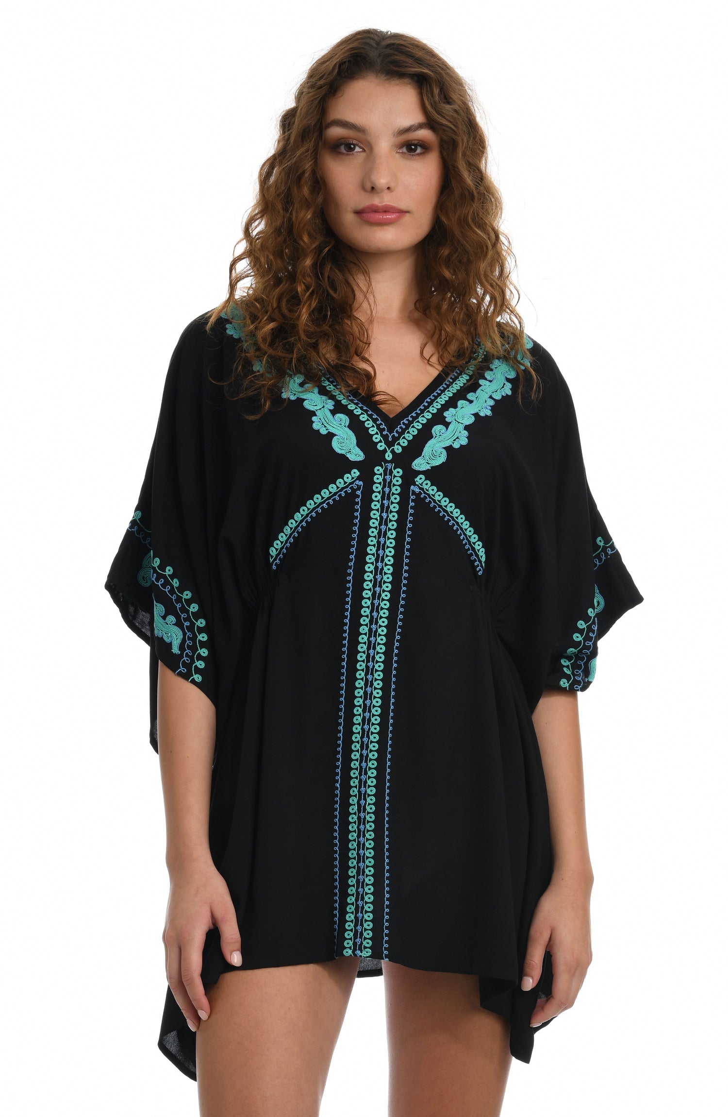 Model is wearing a black V-Neck tunic swimsuit cover up detailed with turquoise embroidered accents from our Hippie Trail collection.