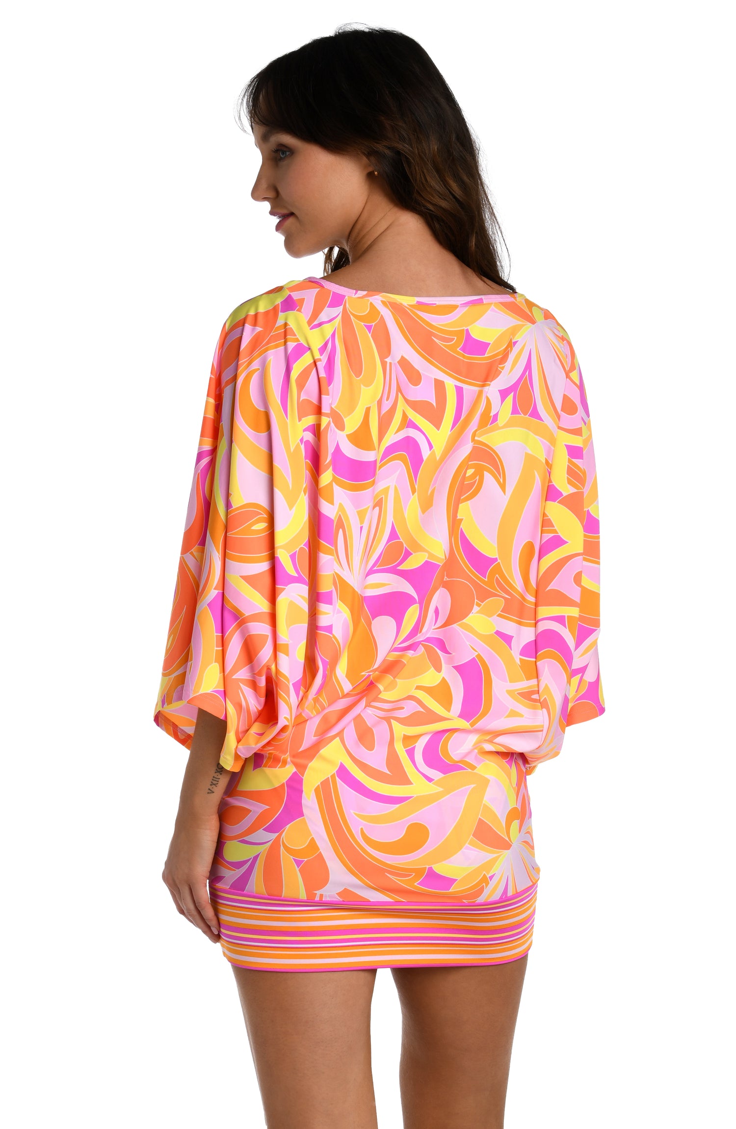 Model is wearing a pink, white, and orange multicolored retro printed short sleeve tunic cover up from our Retro Swirl collection.