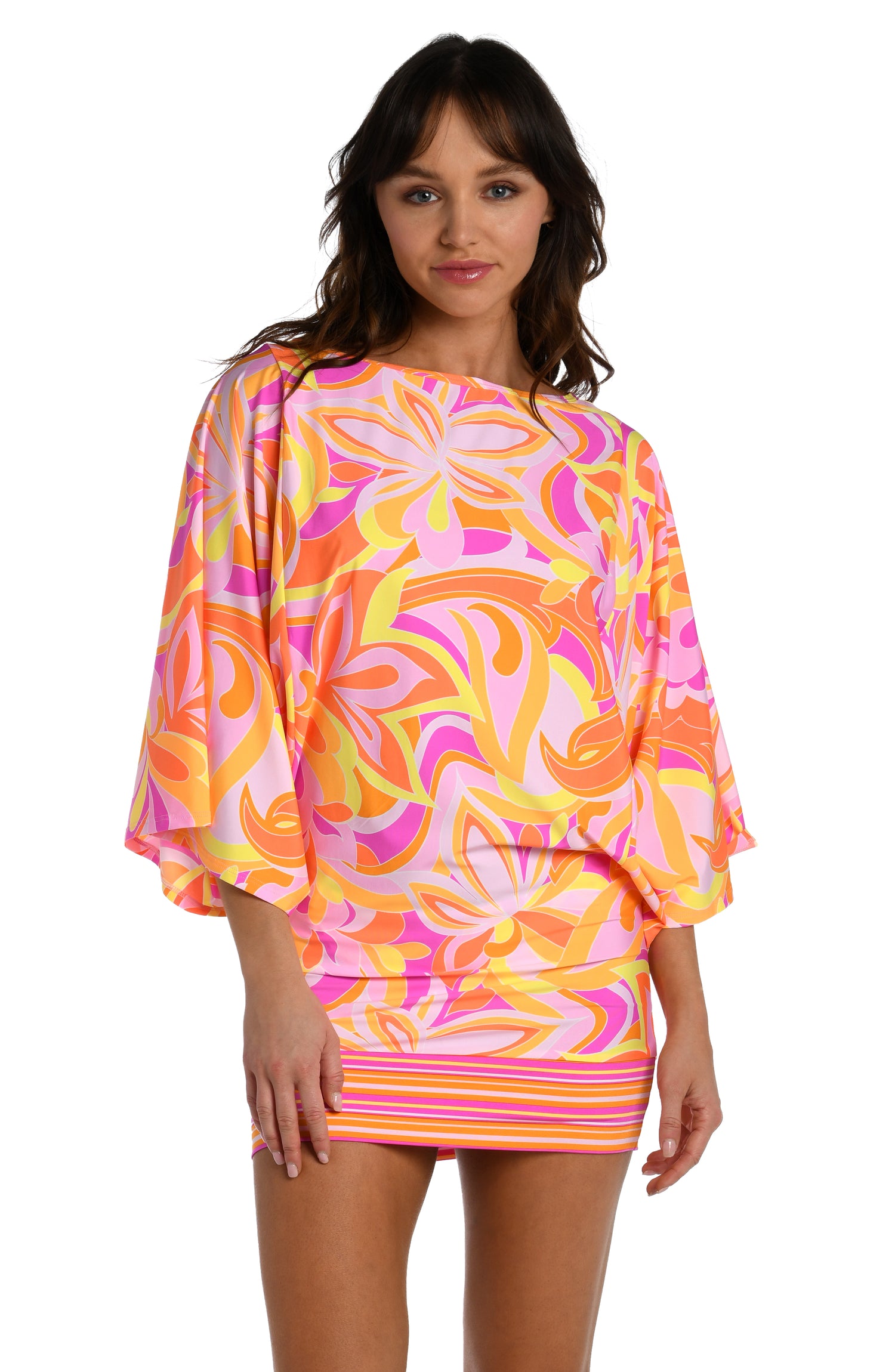 Model is wearing a pink, white, and orange multicolored retro printed short sleeve tunic cover up from our Retro Swirl collection.