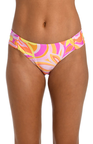 Model is wearing a pink, white, and orange multicolored retro printed side shirred hipster bikini bottom from our Retro Swirl collection.