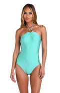 Model is wearing a solid pale, greenish-blue (seaglass) colored high neck one piece swimsuit.