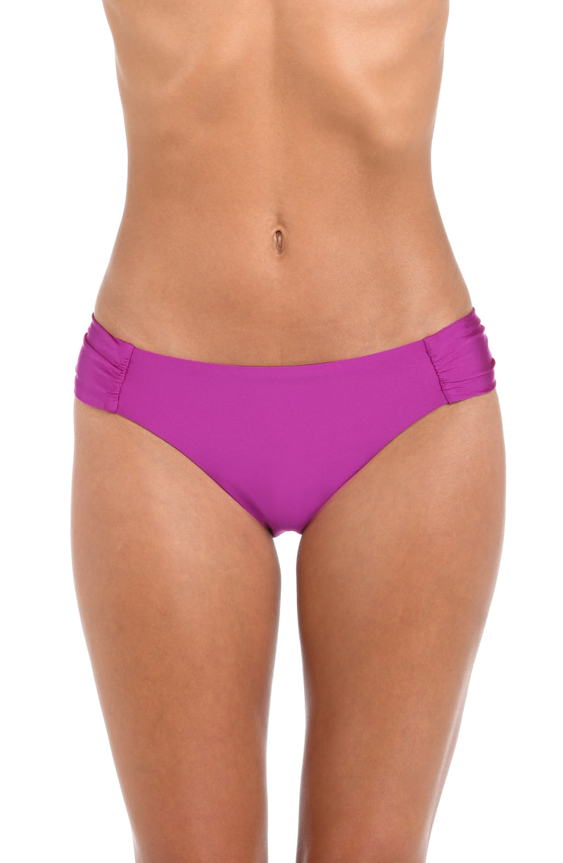 Front image of model wearing a Sunshine 79 Sunshine Solids Side Shirred Hipster Bottom in Bright Violet.