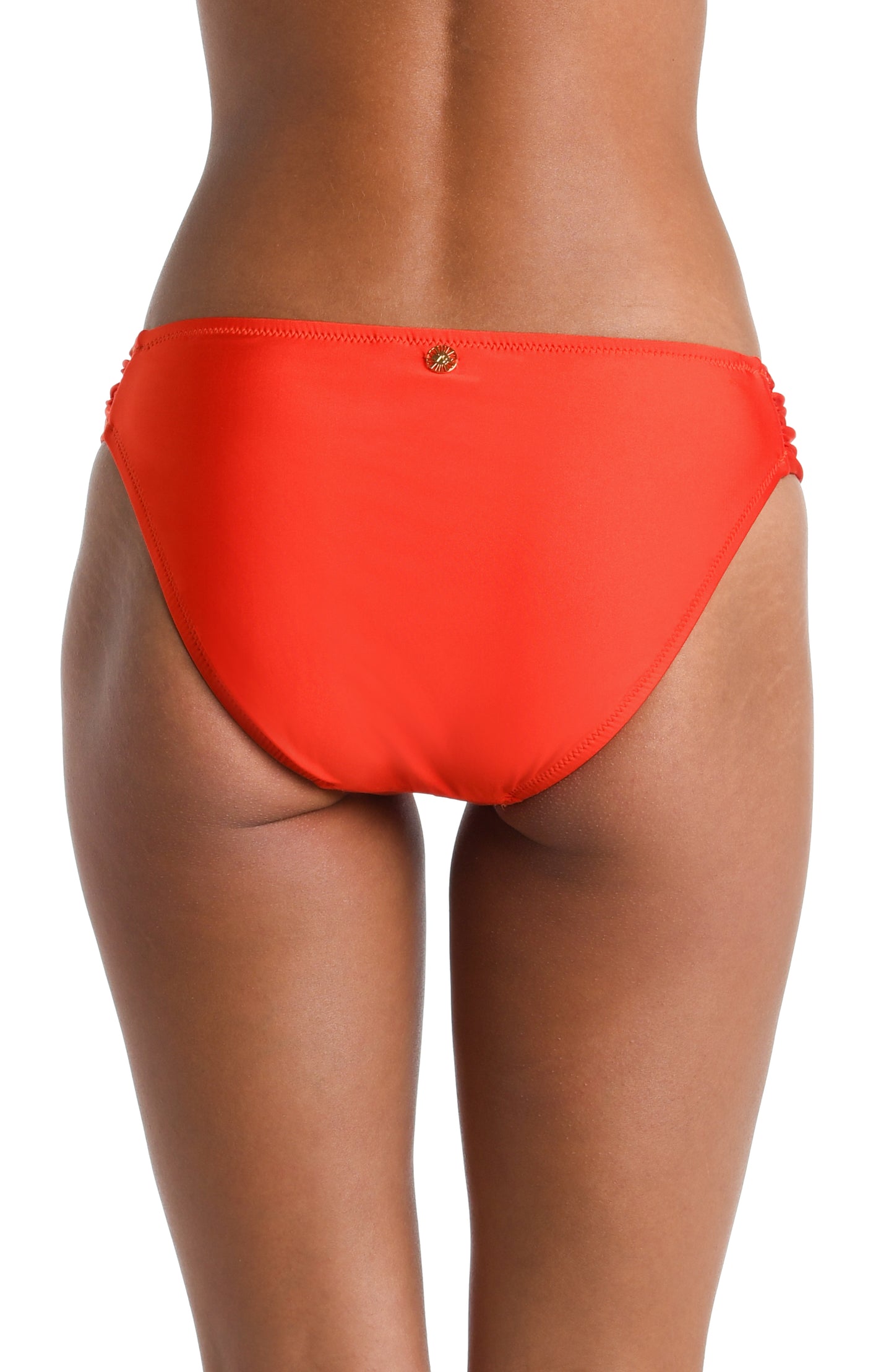 Model is wearing a solid vibrant Flame colored Side Shirred Hipster Bottom