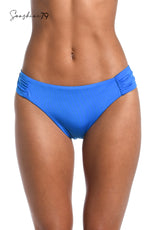 Model is wearing a solid cobalt blue colored side shirred hipster bikini bottom from our Sunshine 79 brand.