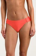 Person wearing bright orange bikini bottoms on a white background