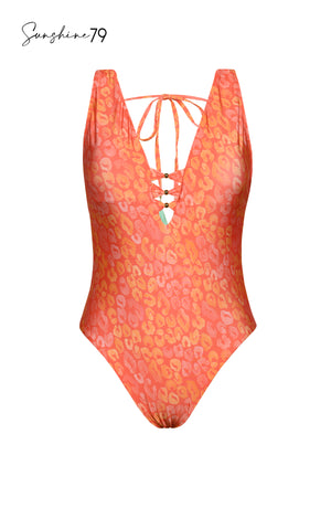 Model is wearing an orange multicolored tropical printed reversible plunge one piece swimsuit from our Sunshine 79 brand.