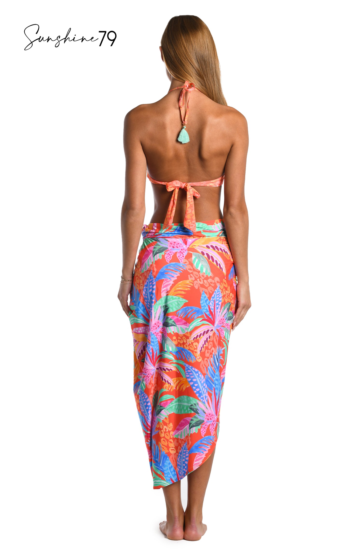 Model is wearing an orange multicolored tropical printed pull on faux pareo wrap cover up from our Sunshine 79 brand.